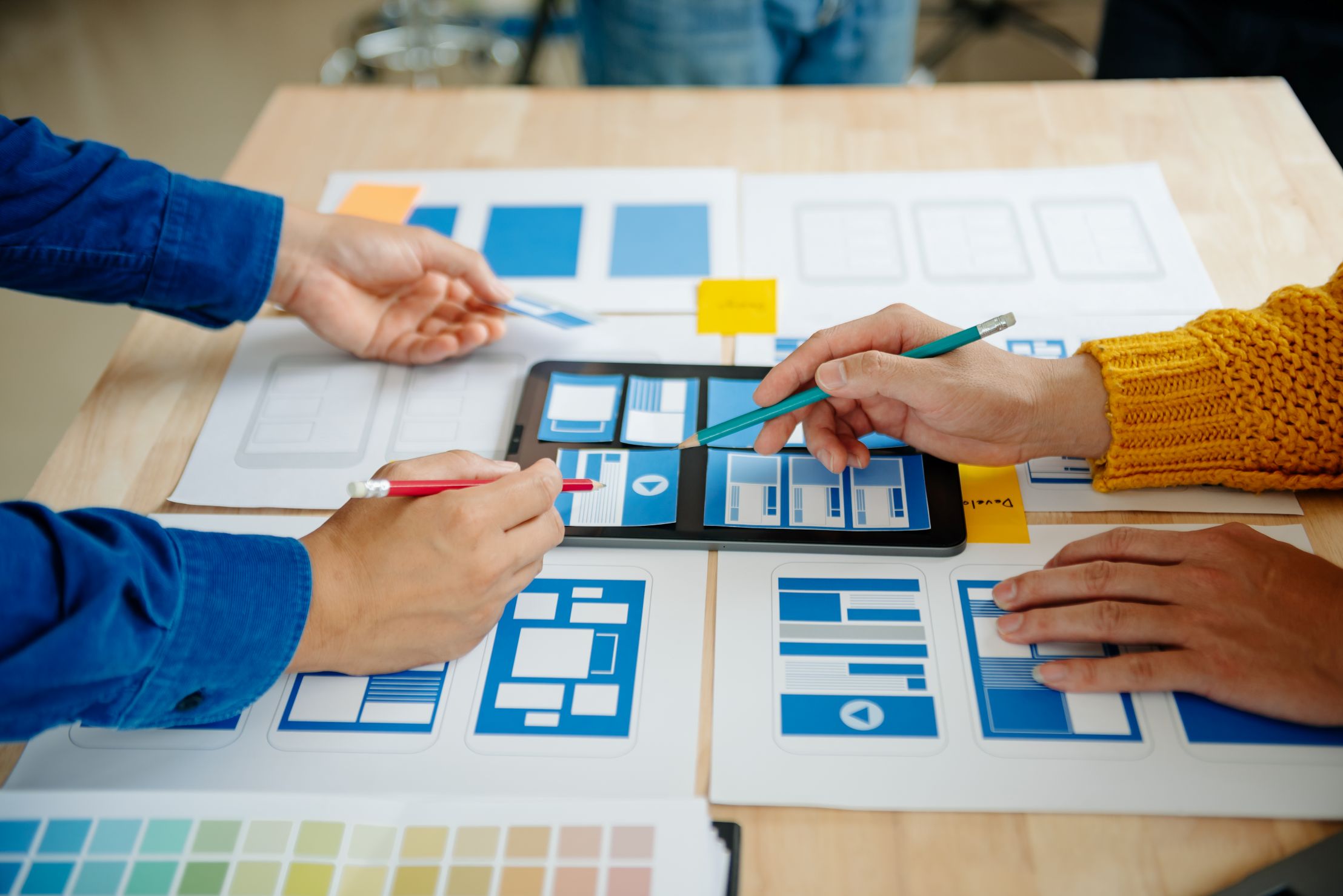 Personas organizando una interfaz y materiales digitales sobre una mesa